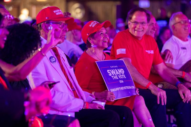 Republican attendees, including Dolly Gil (center), cheer during a presidential debate watch party at gun store and indoor shooting range Adventure Outdoor in Smyrna on Tuesday, Sept. 10, 2024. Candidates Vice President Kamala Harris and former President Donald Trump are debating in Philadelphia. (Arvin Temkar/AJC)