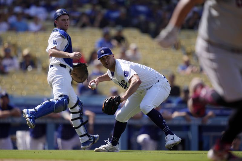 Los Angeles Dodgers starting pitcher Jack Flaherty, center, throws out Cleveland Guardians' Josh Naylor at first as catcher Will Smith, left, watches during the seventh inning of a baseball game, Sunday, Sept. 8, 2024, in Los Angeles. (AP Photo/Mark J. Terrill)