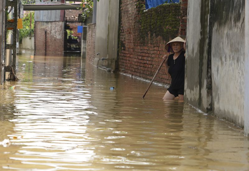 A woman wades in flood in the aftermath of Typhoon Yagi in An Lac village, Hanoi, Vietnam Friday, Sept. 13, 2024. (AP Photo/Hau Dinh)