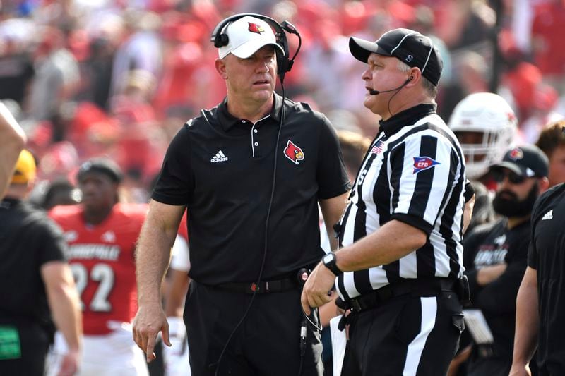 Louisville head coach Jeff Brohm, left, argues with a game official during the first half of an NCAA college football game against Georgia Tech in Louisville, Ky., Saturday, Sept. 21, 2024. (AP Photo/Timothy D. Easley)