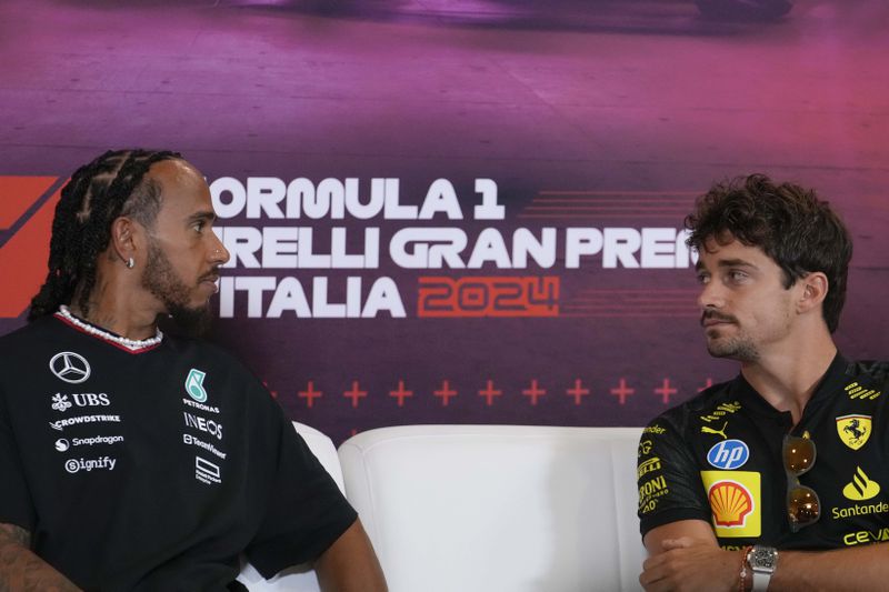 Mercedes driver Lewis Hamilton of Britain and Ferrari driver Charles Leclerc of Monaco look each others during a news conference at the Monza racetrack, in Monza, Italy, Thursday, Aug.29, 2024. The Formula one race will be held on Sunday. (AP Photo/Luca Bruno)