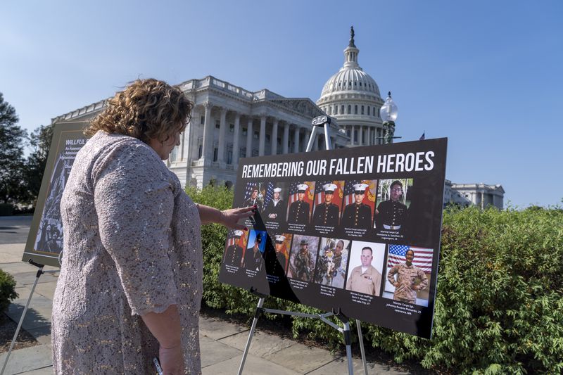 Paula Knauss touches the photo of her son Staff Sgt. Ryan C. Knauss, of Corryton, Tenn., who died during the U.S. withdrawal in Afghanistan, before a news conference at the Capitol in Washington, Monday, Sept. 9, 2024. The House Foreign Affairs Committee has released a scathing report on their investigation into the U.S. withdrawal from Afghanistan. (AP Photo/J. Scott Applewhite)