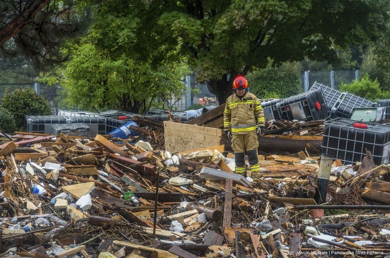 This handout photo provided by the Polish fire department, shows firefighters removing piles of debris dumped in the streets by high flood wave that is passing through southwestern Poland, in Glucholazy, Poland, on Tuesday, Sept. 17, 2024. ( Marcin Muskala/KG PSP via AP)