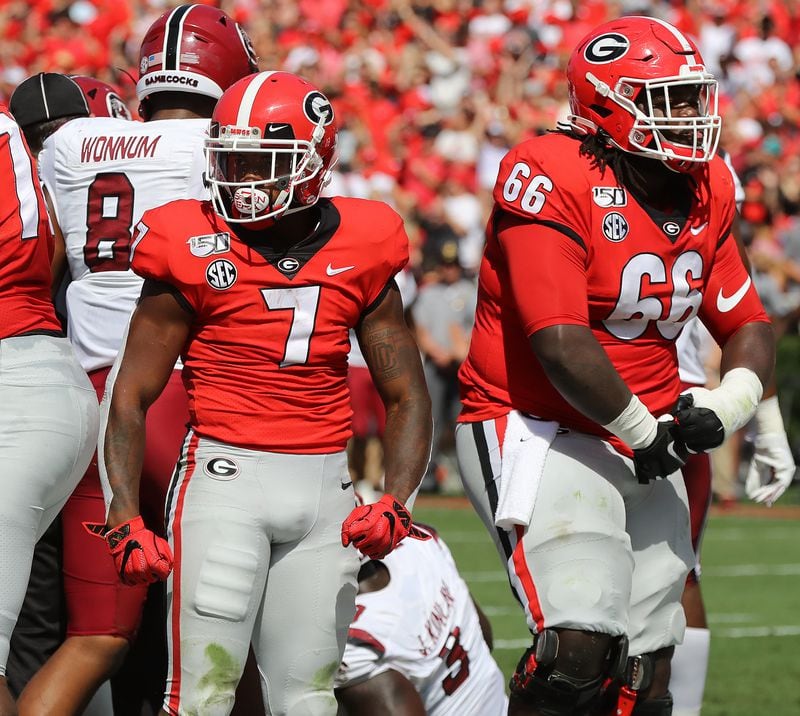 Georgia tailback D'Andre Swift (left) and offensive lineman Solomon Kindley flex after Swift powered his way into the end zone.    Curtis Compton/ccompton@ajc.com