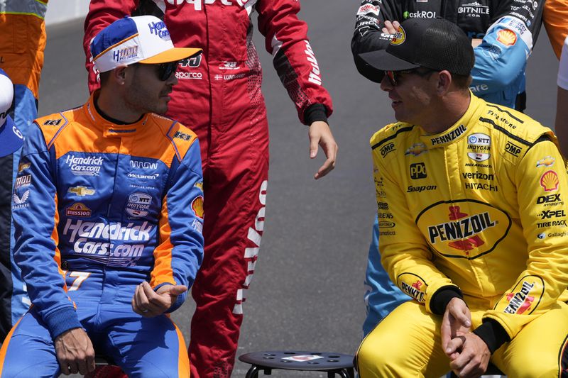 Kyle Larson talks with Scott McLaughlin, of New Zealand, before a practice session for the Indianapolis 500 auto race at Indianapolis Motor Speedway, Monday, May 20, 2024, in Indianapolis. (AP Photo/Darron Cummings)
