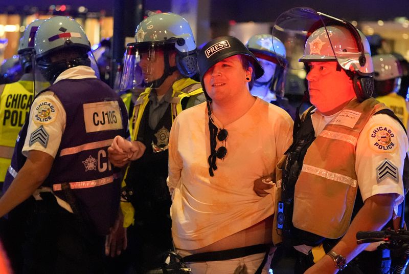 A demonstrators is taken into custody by police police near the Israeli Consulate during the Democratic National Convention Tuesday, Aug. 20, 2024, in Chicago. (AP Photo/Julio Cortez)