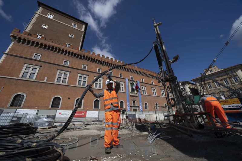 Workers inject reactive chemicals to consolidate the construction site of the new 25.5-kilometer Metro C subway main hub in Piazza Venezia in central Rome, Thursday, May 23, 2024. During a tour Thursday of the construction site at Piazza Venezia, chief engineer Andrea Sciotti said works on the nearly 3 billion euro project, considered one of the most complicated in the world, were running at pace to be completed by 2034. In the background the Unknown Soldier monument. (AP Photo/Domenico Stinellis)
