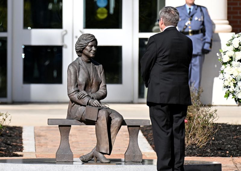 Chip Carter pauses by a statue of his mother during a wreath laying ceremony at the Rosalynn Carter Health & Human Services complex at Georgia Southwestern State University on Nov. 27, 2023, in Americus. (Hyosub Shin/AJC)