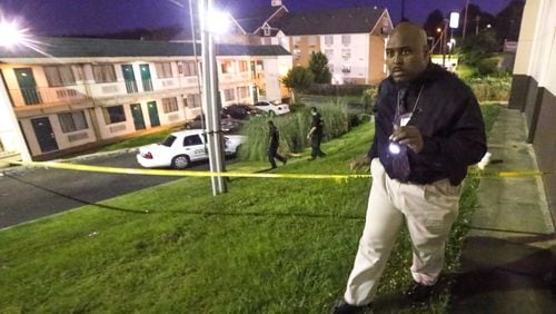 From June 2015: Cobb County police detective M. J. Hill combs the surrounding area of the Masters Inn on Windy Hill Road after a man was shot and killed on the breezeway of the hotel.