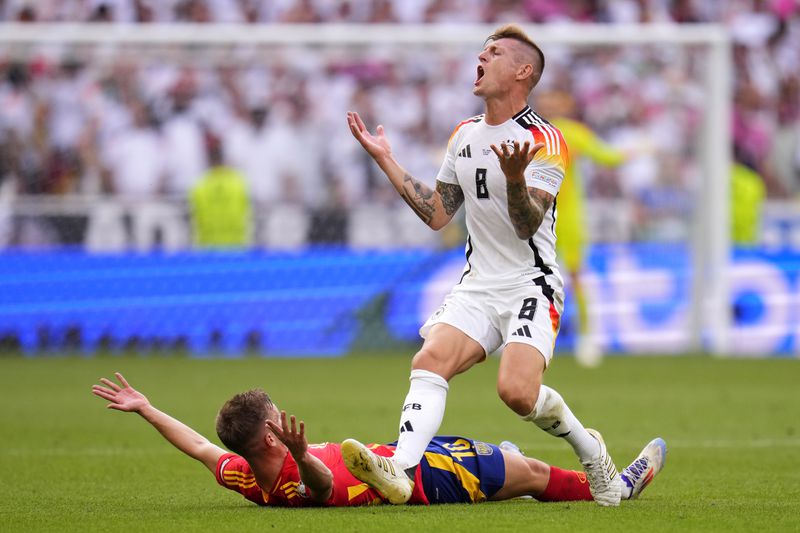 Germany's Toni Kroos, right, and Spain's Dani Olmo gesture during a quarter final match between Germany and Spain at the Euro 2024 soccer tournament in Stuttgart, Germany, Friday, July 5, 2024. (AP Photo/Manu Fernandez)