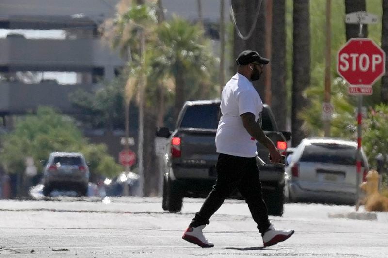 FILE - A pedestrian crosses a street as heat waves rise from the pavement as the temperature hits 104-degrees Monday, June 17, 2024, in Phoenix. (AP Photo/Ross D. Franklin, File)