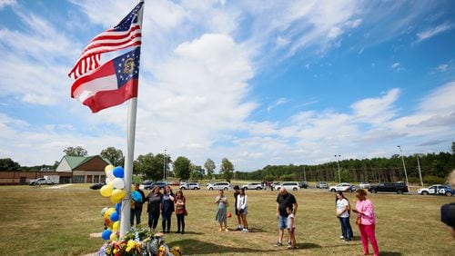 Community members gathered by the flag pole to pay respect to the victims at Apalachee High School in Winder, Georgia, on Thursday, September 5, 2024. A day after, a 14-year-old opened fire at a Barrow County high school on Wednesday morning, killing two students and two teachers and injuring nine others. (Miguel Marttinez/AJC)