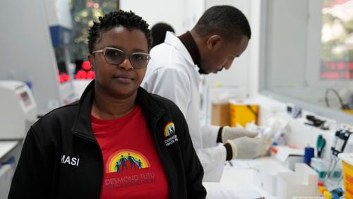 Clinical trials co-ordinator Thandeka Nkosi, stands in front of Lab technician, Xolile Mhlanga, who works with vials of lenacapavir, at the Desmond Tutu Health Foundation's Masiphumelele Research Site, in Cape Town, South Africa, Tuesday, July 23, 2024. The prospect of a twice-a-year shot is “quite revolutionary news” for our patients,” said Nkosi, who helped run the Gilead research at the Foundation in Masiphumelele. (AP Photo/Nardus Engelbrecht)