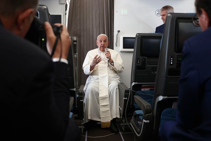 Pope Francis holds a news conference aboard the papal plane on his flight back after his 12-day journey across Southeast Asia and Oceania, Friday, Sept. 13, 2024. (Guglielmo Mangiapane/Pool Photo via AP)