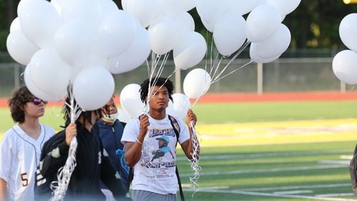 Henry County, Monday May 16, 2022 — Student CJ Hardy carries balloons for students, staff, and family members who gathered at Eagle’s Landing High School for a vigil to mourn the lives of 16-year-old Kendarius Jackson, 16-year-old Kenderrias Dodson, 15-year-old Katrina Owens and 15-year-old Jordan Brown who died in a car crash last Wednesday. Zakrya Jones, 15, survived the crash. (TYSON HORNE / TYSON.HORNE@AJC.COM)