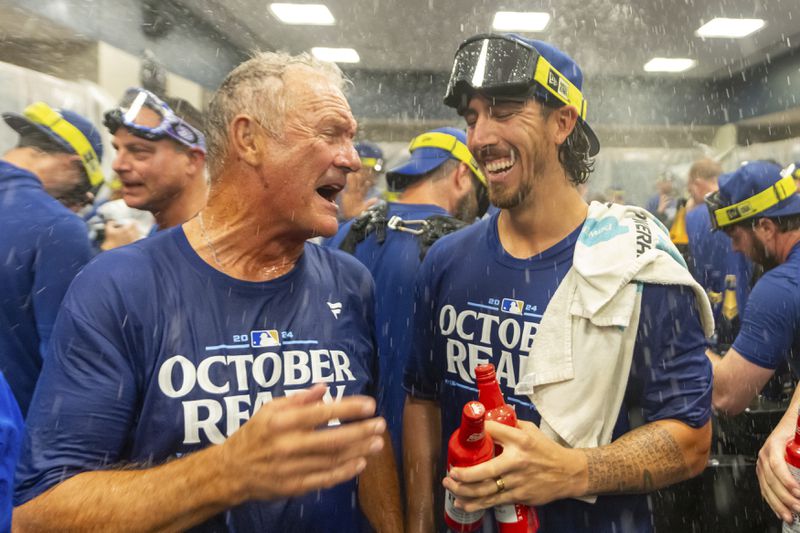 Hall of Fame Kansas City Royals' infielder George Brett, left, celebrates with pitcher Michael Lorenzen, right, in the locker room after a baseball game against the Atlanta Braves, Friday, Sept. 27, 2024, in Atlanta. (AP Photo/Jason Allen)