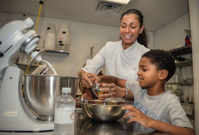 Shiana White, owner of A Haute Cookie, helps Jacadi Robinson, 8, with his version of Edible Sugar Cookie Dough. CONTRIBUTED BY CHRIS HUNT PHOTOGRAPHY