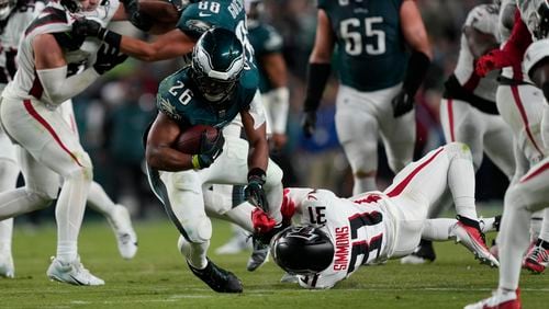 Atlanta Falcons safety Justin Simmons (31) stops Philadelphia Eagles running back Saquon Barkley (26) during the second half of an NFL football game Monday, Sept. 16, 2024, in Philadelphia. (AP Photo/Matt Rourke)