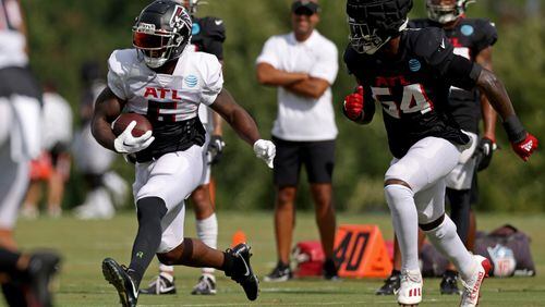 Falcons running back Damien Williams (6) runs after a catch against inside linebacker Rashaan Evans (54) during training camp at the Falcons Practice Facility, Wednesday, August 10, 2022, in Flowery Branch, Ga. (Jason Getz / Jason.Getz@ajc.com)