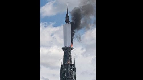 In this photo provided by Vivien Leservoisier, a view of the spire of Roeun cathedral on fire, in Rouen, France, Thursday, July 11, 2024. A fire broke out in the spire of the medieval cathedral in the northern French city of Rouen but authorities said it was under control about 90 minutes later. Witnesses told French television that smoke was emanating from the spire, and recalled a devastating fire in 2019 at Notre Dame Cathedral in Paris that toppled its spire and collapsed its roof. (Vivien Leservoisier via AP)
