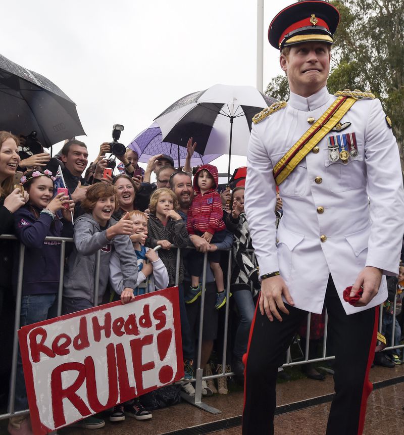 FILE - Britain's Prince Harry, right, as he reacts after shaking hands with kids holding up a sign during a visit to the Australian War Memorial in Canberra, Australia, Monday, April 6, 2015. (AP Photo/Lukas Coch, Pool, File)