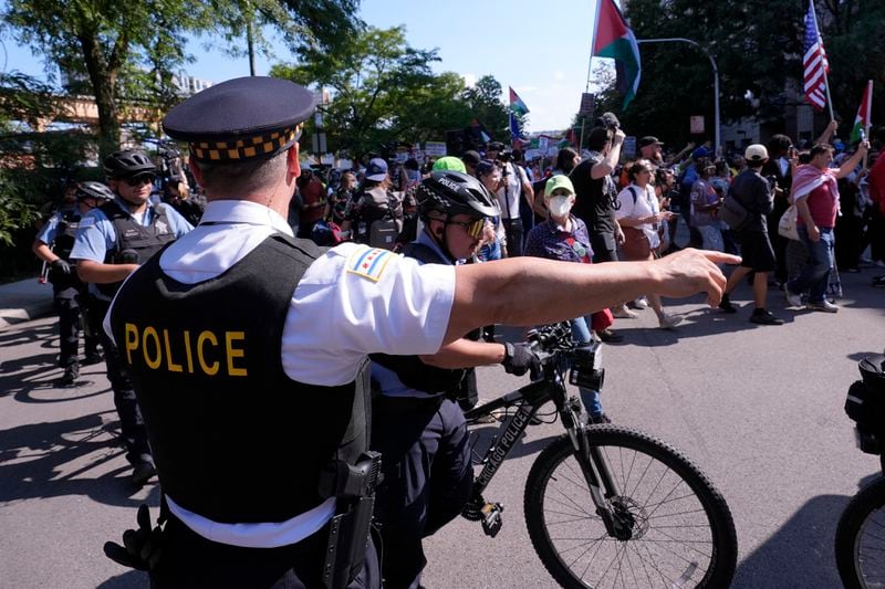 A police officer directs protesters during a march to the Democratic National Convention after a rally at Union Park Monday, Aug. 19, 2024, in Chicago. (AP Photo/Alex Brandon)