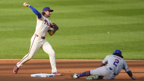 Philadelphia Phillies' Bryson Stott, left, throws to first for a double play as New York Mets' Luisangel Acuna slides during the fourth inning of a baseball game, Saturday, Sept. 14, 2024, in Philadelphia. (AP Photo/Derik Hamilton)