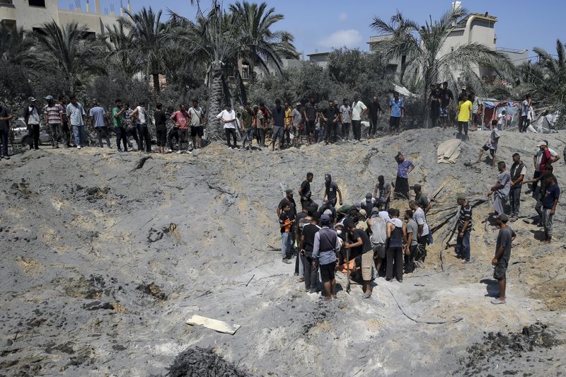 Palestinians search for bodies and survivors in a site hit by an Israeli bombardment on Khan Younis, southern Gaza Strip, Saturday, July 13, 2024. Israel said it targeted Hamas’ shadowy military commander in a massive strike Saturday in the crowded southern Gaza Strip that killed at least 71 people, according to local health officials. Hamas immediately rejected the claim that Mohammed Deif was in the area. (AP Photo/Jehad Alshrafi)