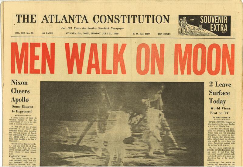 An Atlanta Constitution front page from Monday morning, July 21, the morning after the moon walk, was marked as a "souvenir extra" with a headline, Men Walk on Moon above a photo of Armstrong and Aldrin on the lunar surface the night before.  (AJC archives)