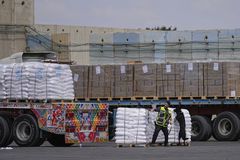 FILE - Trucks carrying humanitarian aid for the Gaza Strip pass through the inspection area at the Kerem Shalom Crossing in southern Israel, Thursday, March 14, 2024. A persistent breakdown in law and order is rendering an aid route in south Gaza unusable, the UN and NGOs say, days after Israel's military said it would pause combat there to help aid reach desperate Palestinians. (AP Photo/Ohad Zwigenberg, File)