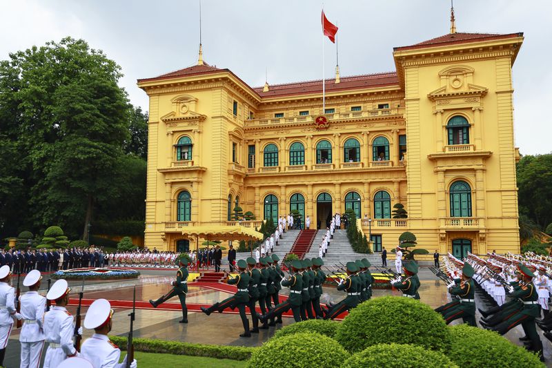 Russian President Vladimir Putin, background left, and Vietnamese President To Lam, background right, both are on a podium, attend an official welcome ceremony at the Presidential Palace, in Hanoi, Thursday, June 20, 2024. (Vladimir Smirnov, Sputnik, Kremlin Pool Photo via AP)