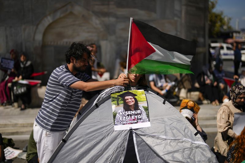 Demonstrators place a Palestinian flag next to a photograph of Aysenur Ezgi Eygi, 26 year-old Turkish-American activist killed by the Israeli military, during a protest in her memory in Istanbul, Turkey, Saturday, Sept. 14, 2024. (AP Photo/Francisco Seco)