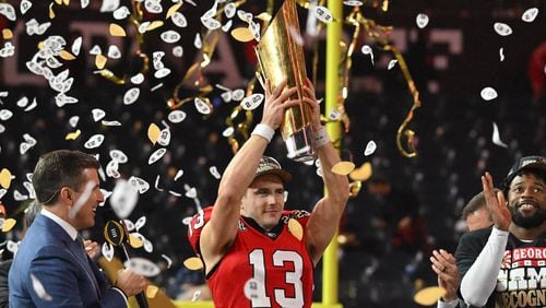 Georgia's quarterback Stetson Bennett (13) holds up the National Championship Trophy during the 2023 College Football Playoff National Championship game at SoFi Stadium, Monday, Jan. 9, 2023, in Inglewood, California.  The Bulldogs reportedly have yet to receive an invitation to visit the White House in Washington, D.C. (Hyosub Shin/The Atlanta Journal-Constitution)