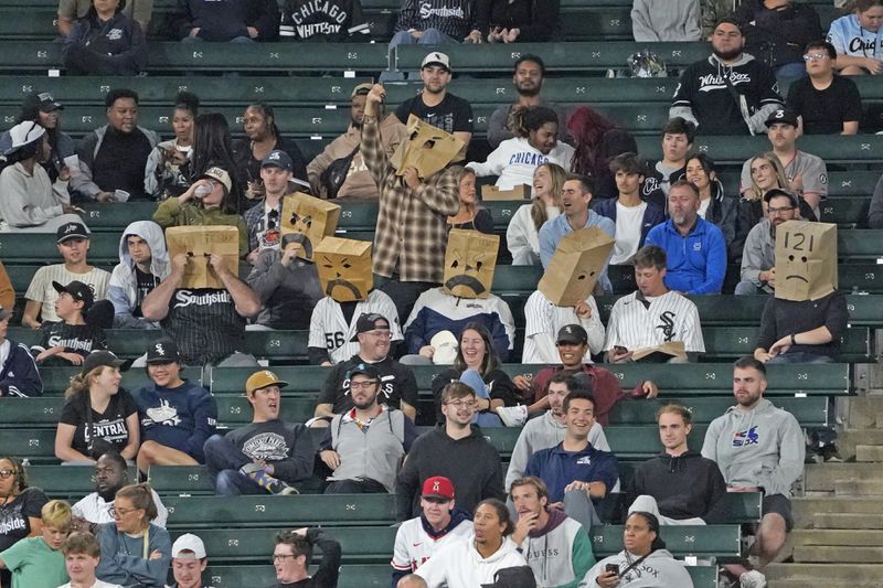 Chicago White Sox fans sit in the stands with bags on their head during the 10th inning of a baseball game between the White Sox and the Los Angeles Angels, Wednesday, Sept. 25, 2024, in Chicago. (AP Photo/David Banks)