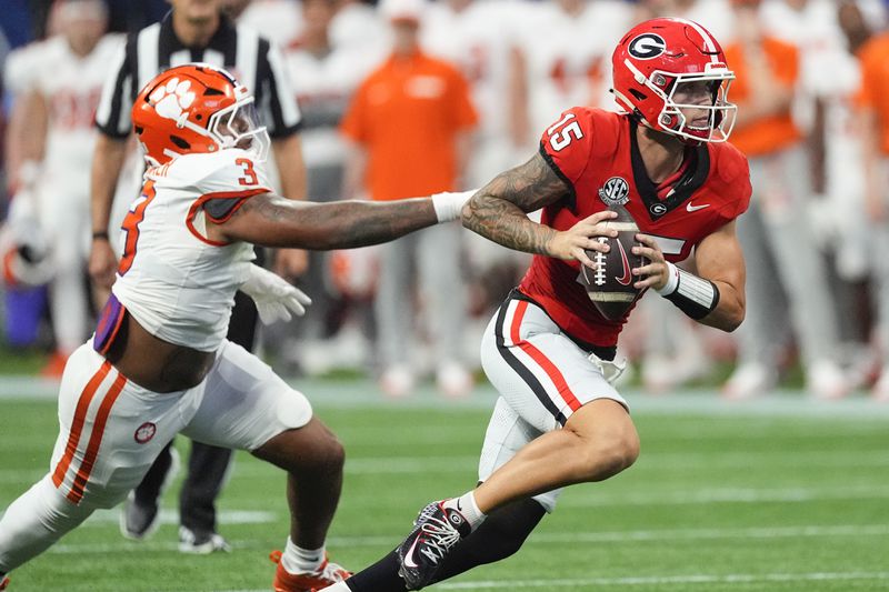 Georgia quarterback Carson Beck (15) escapes from Clemson defensive end T.J. Parker (3) during the second half of an NCAA college football game Aug. 31, 2024, in Atlanta. (AP Photo/John Bazemore)