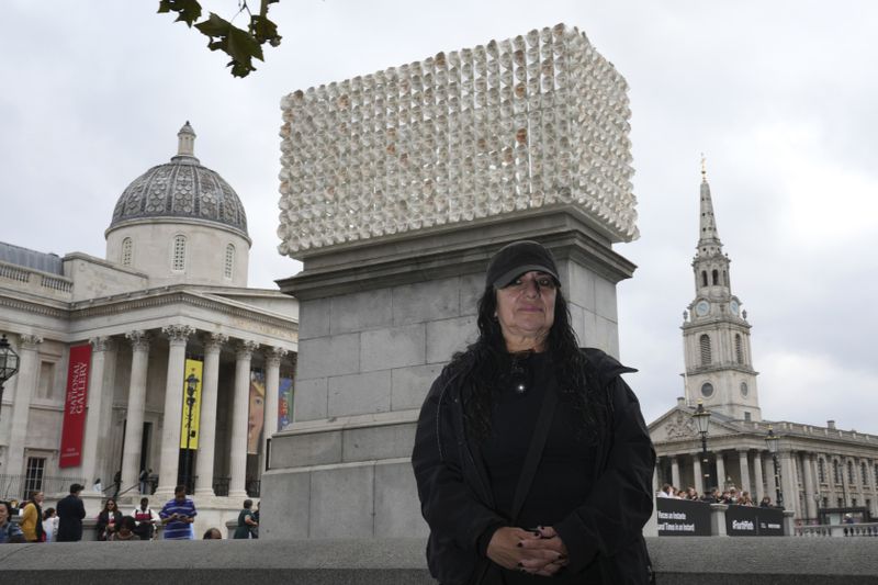 Mexican artist Teresa Margolles poses in front of her artwork "Mil Veces un Instante (A Thousand Times in an Instant)" for the Fourth Plinth, marking 25 years of the ground-breaking commissioning programme for public art at Trafalgar Square, in London, Wednesday, Sept. 18, 2024. (AP Photo/Kin Cheung)