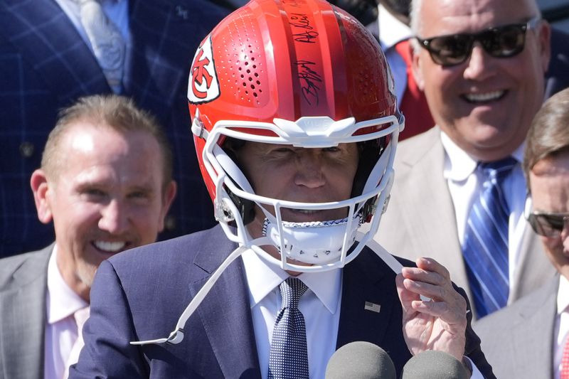 President Joe Biden wears a Chiefs helmet as he speaks during an event with the Super Bowl-champion Kansas City Chiefs on the South Lawn of the White House, Friday, May 31, 2024, to celebrate their championship season and victory in Super Bowl LVIII. (AP Photo/Evan Vucci)