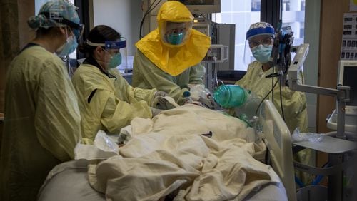 Pulmonologist Dr. Laren Tan, center, with his medical team of nurses and respiratory therapists intubate a COVID-19 patient who's oxygen levels were dropping in the ICU at Loma Linda University Medical Center on December 15, 2020 in Loma Linda, California. The hospital is experiencing a huge surge in COVID-19 patients. (Gina Ferazzi/Los Angeles Times/TNS)