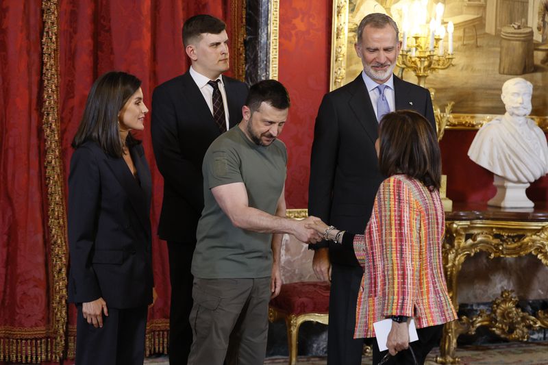 Flanked by Spain's King Felipe VI and Queen Letizia, Ukrainian President Volodymyr Zelenskyy, center, shakes hands with Spain's Defense Minister Margarita Robles at the Royal Palace in Madrid on Monday, May 27, 2024. (Ballesteros/Pool via AP)