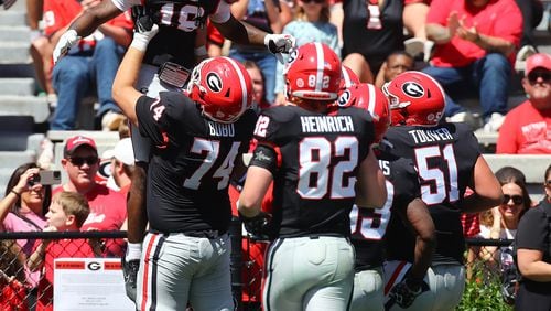 041324 Athens: Drew Bobo (74) hoists receiver Sacovie White in the air after White scored a touchdown to give the black team a 17-13 lead during the G-Day game on Saturday, April 13, 2024.  Curtis Compton for the Atlanta Journal Constitution