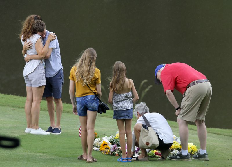 Mourners embrace at a memorial for Gene Siller, a man shot and killed Saturday, at Pinetree Country Club in Kennesaw on Friday, July 9, 2021. Two other men were found dead in the bed of a pickup truck at the country club course. Bryan Rhoden, 23, was arrested Thursday for the killings. (Christine Tannous / christine.tannous@ajc.com)