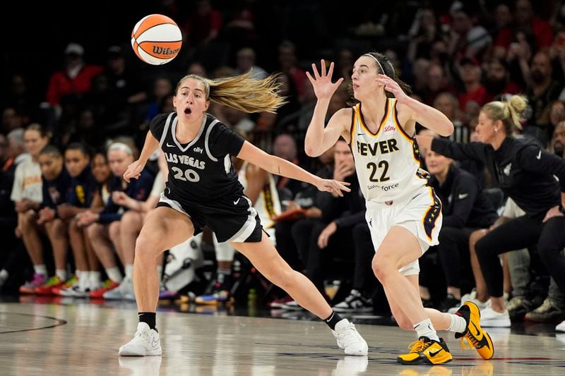 Indiana Fever guard Caitlin Clark (22) passes around Las Vegas Aces guard Kate Martin (20) during the first half of a WNBA basketball game Saturday, May 25, 2024, in Las Vegas. (AP Photo/John Locher)