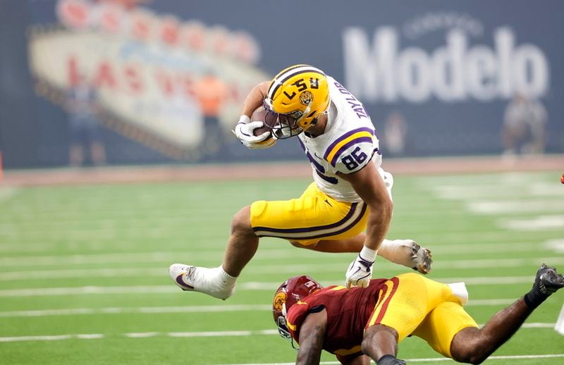 LSU tight end Mason Taylor (86) is tripped by Southern California safety Kamari Ramsey, bottom, during the first half of an NCAA college football game Sunday, Sept. 1, 2024, in Las Vegas. (AP Photo/Steve Marcus)