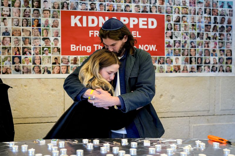 People embrace after lighting candles at a synagogue in Germany where a ceremony was held marking the first anniversary of the Hamas attacks on Israel.