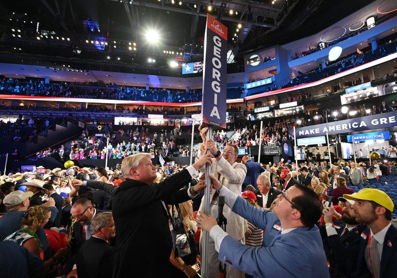 Georgia Republican Party Chairman Josh McKoon (right) helps to pick up the Georgia delegate marker on the final day of Republican National Convention in Milwaukee.