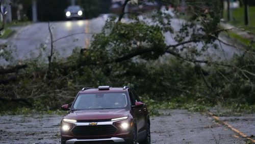 Vehicles move slowly around trees that have fallen after Hurricane Helene, Friday, Sept. 27, 2024, in Valdosta, Ga. (AP Photo/Mike Stewart)