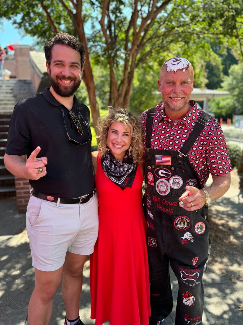 Hampton Woods (left) is set to continue the Woods family tradition of painting the Georgia Bulldogs logo on his head. He will become the fifth generation in his family to wear the logo. His dad, Mike Woods Jr. (right) is assuming his role in the Woods family line in the 2024 season. Before Mike there was Trent Woods, who died in February 2024. Hampton and Mike are pictured with Christine Woods, Hampton's mom and Mike's wife. (Photo courtesy of Mike Woods)