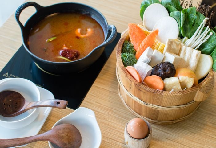 A hotpot meal with herbal broth (left) and the vegetarian entree (right) at J's Mini Hotpot Deluxe. CONTRIBUTED BY HENRI HOLLIS