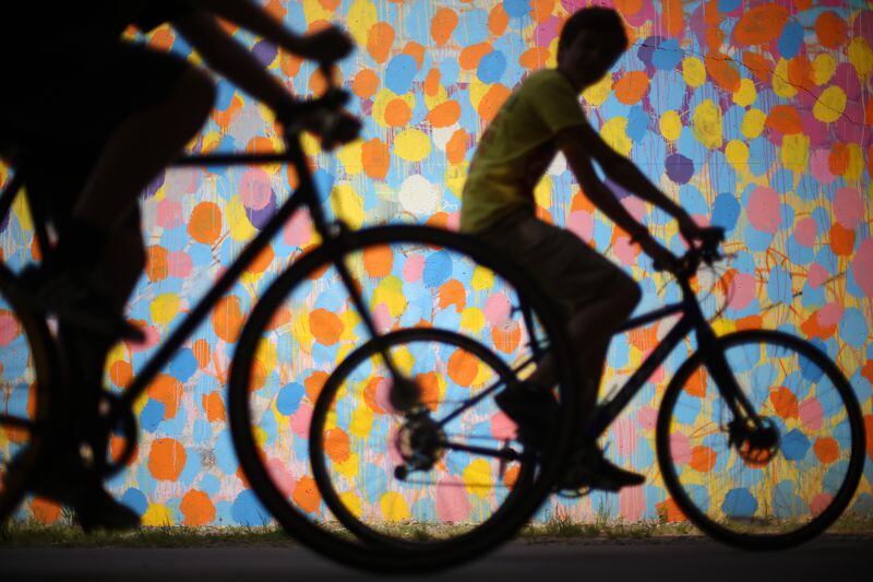 Bicyclists cruise along the Beltline past a mural by HENSE under Virginia Avenue. Ben Gray / bgray@ajc.com