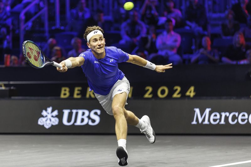 Casper Ruud returns a ball to Argentina's Francisco Cerundolo during their men's singles Laver Cup tennis match at the Uber Arena in Berlin, Germany, Friday Sept. 20, 2024. (Andreas Gora/dpa via AP)